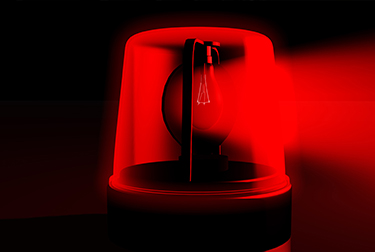 Image of a red emergency light on a black background.